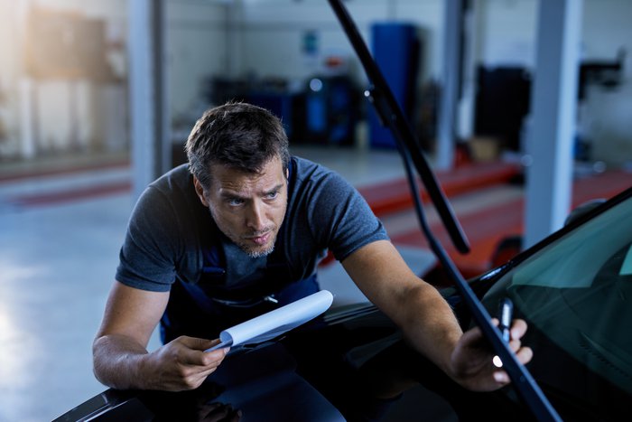 car-mechanic-examining-vehicle-problems-while-working-at-auto-repair-shop.jpg